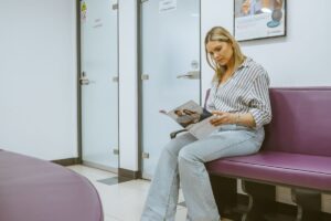 Patient reading a dental information brochure in the waiting area at Lodge Causeway Dental Centre