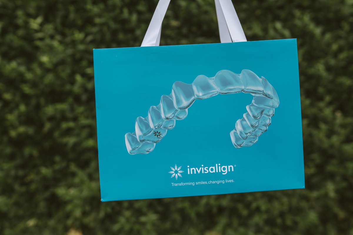 Invisalign treatment bag featuring a clear dental aligner against a natural outdoor background